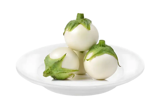 Trois angivy naturels, aubergines blanches malgaches, présentées sur une assiette blanche, légume authentique pour cuisine exotique.