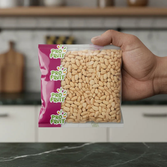 Sachet d’arachide blanche PROFRUIT tenu à la main dans une cuisine moderne, produit sec de qualité pour épicerie sucrée.