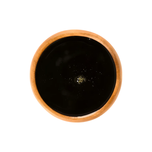Vue de dessus d’un bol en bois rempli de sirop de batterie DORMOY, sirop épais et foncé issu de la canne à sucre naturelle.