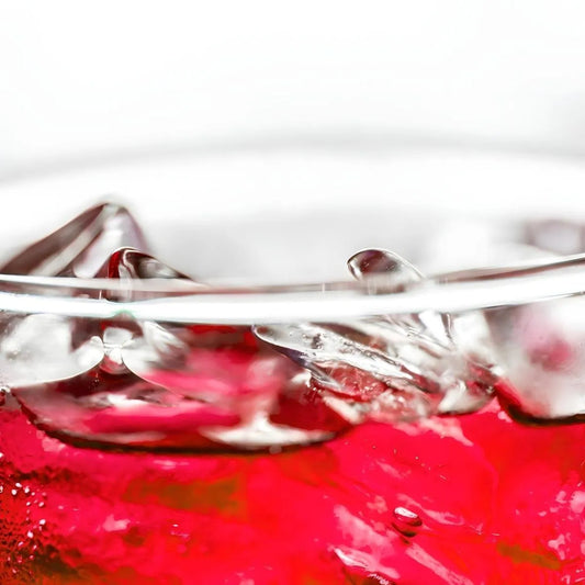 Verre de soda grenadine ROYAL SODA avec glaçons, boisson rouge pétillante parfaite pour se rafraîchir, saveur fruitée intense.