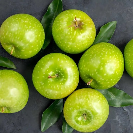Pommes vertes fraîches disposées sur fond sombre, ingrédient principal du soda pomme verte GAZOUZ - BOISSON - NKOSI.