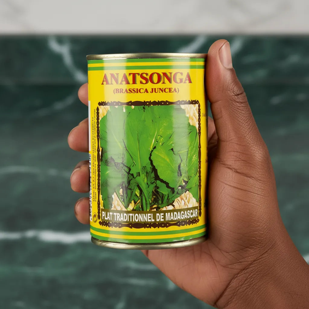 Main tenant une boîte d’Anatsonga CODAL, conserve de légumes-feuilles surgelés, idéale pour cuisine rapide et traditionnelle malgache.