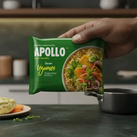Main tenant un paquet de nouilles légumes APOLLO dans une cuisine moderne, produit pratique pour repas express et équilibrés.