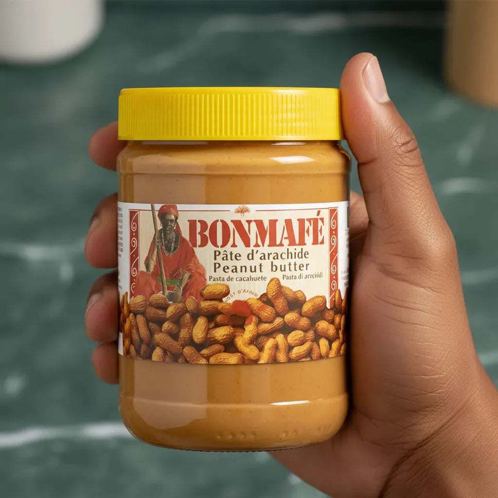 Main tenant un pot de pâte d'arachide BONMAFE - Crème riche aux arachides sélectionnées, parfaite pour tartiner ou cuisiner, épicerie sucrée.