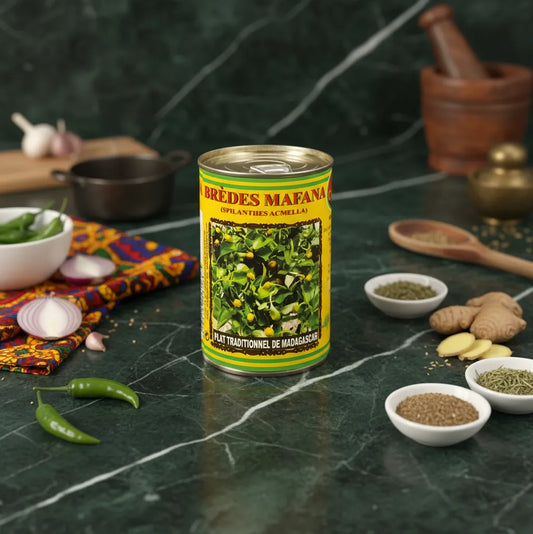 Boîte de brèdes mafana CODAL posée sur un plan de travail avec épices et légumes, parfaite pour cuisine traditionnelle malgache.