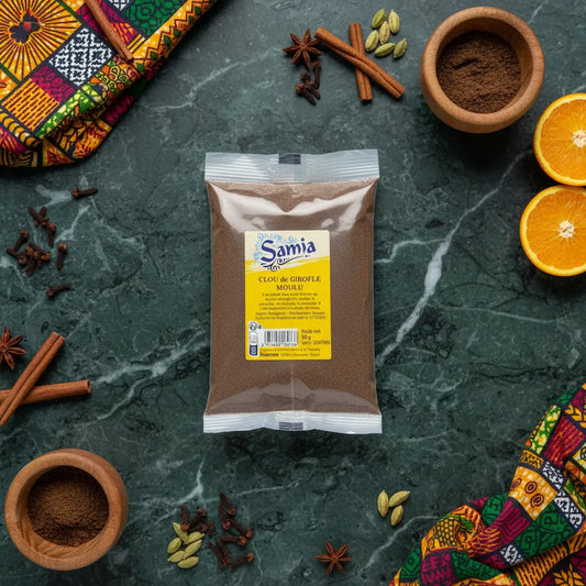 Sachet de clous de girofle moulu SAMIA posé sur une table avec épices et agrumes - Épicerie salée pour cuisine parfumée et savoureuse.