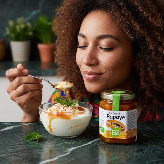 Femme dégustant un dessert au yaourt garni de confiture papaye RACINES BIO. Confiture bio idéale pour petits-déjeuners et desserts fruités.