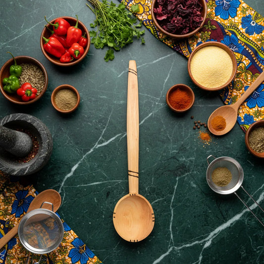 Cuillère en bois artisanale africaine posée sur un plan de travail avec épices et légumes, parfaite pour une cuisine esthétique et fonctionnelle.