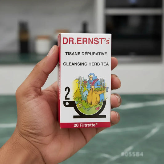 Main tenant une boîte de Tisane Dépurative DR ERNST'S, 20 sachets, infusion naturelle pour soutenir les fonctions naturelles du corps.