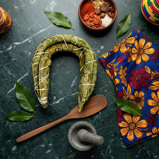 Bobolo frais fermenté présenté avec des épices africaines et accessoires de cuisine, idéal pour plats traditionnels riches en fibres.