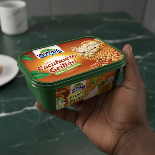 Main tenant un bac de glace cacahuète grillée PARADIS GLACE, format pratique pour desserts glacés gourmands à la cacahuète.