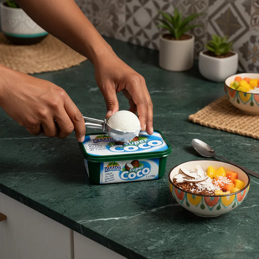 Personne servant une boule de glace coco Super Coco Paradis Glace dans un bol avec fruits frais. Dessert glacé tropical de l’épicerie sucrée.