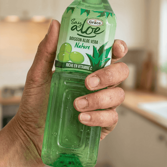 Main tenant une bouteille de Jus Aloe Vera GRACE Nature, boisson hydratante avec pulpe visible. Riche en vitamine C pour une vitalité naturelle.