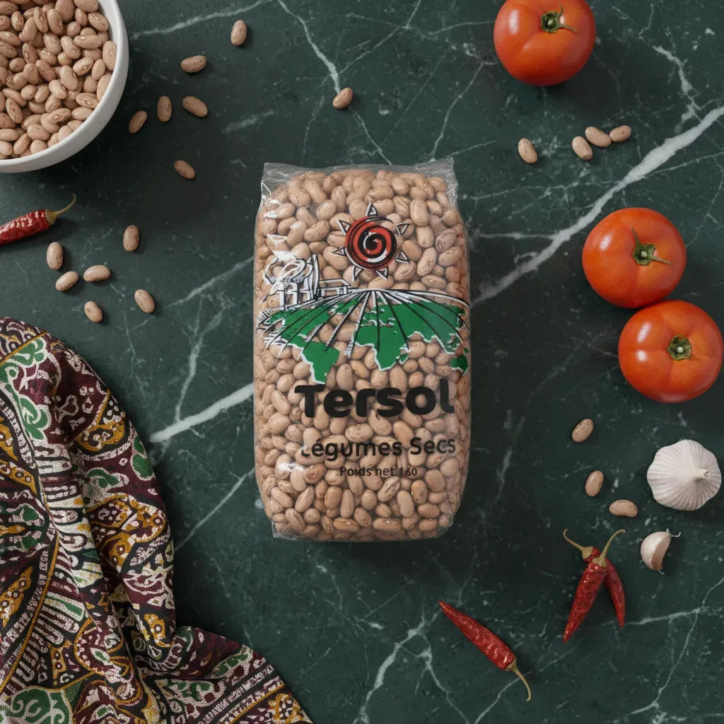 Sachet de haricot coco rose TERSOL posé sur table avec tomates, ail et piments, ingrédient essentiel pour recettes maison.