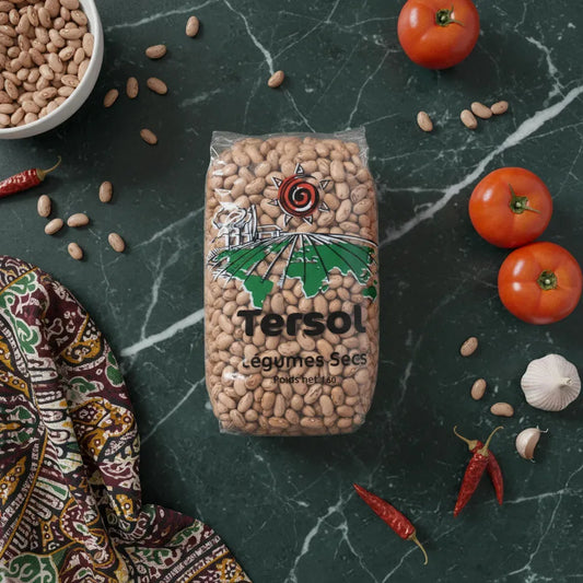 Sachet de haricot coco rose TERSOL posé sur table avec tomates, ail et piments, ingrédient essentiel pour recettes maison.