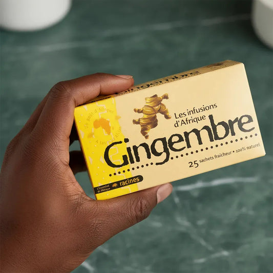 Main tenant une boîte d'infusion gingembre bio RACINES 100% naturelle, 25 sachets fraîcheur, design jaune et noir distinctif.
