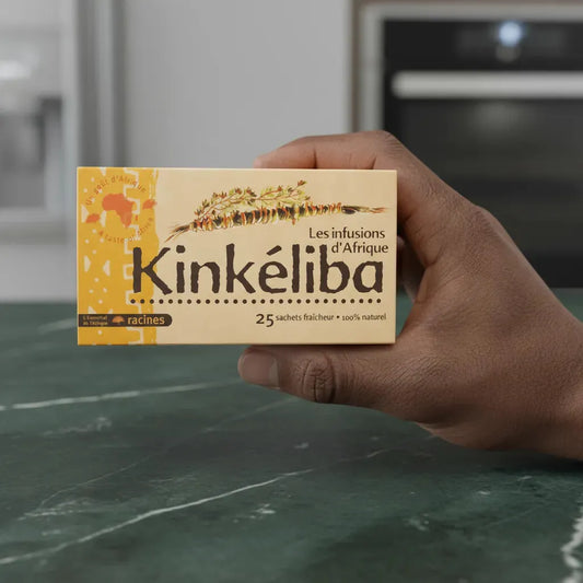 Main tenant une boîte d'infusion d'Afrique Kinkeliba RACINES, 25 sachets naturels, boisson traditionnelle aux vertus bien-être.