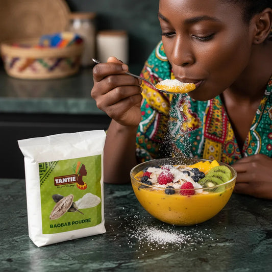 Femme dégustant un smoothie bowl garni de fruits et de poudre de baobab TANTIE, parfaite pour enrichir les recettes santé et nutritives.