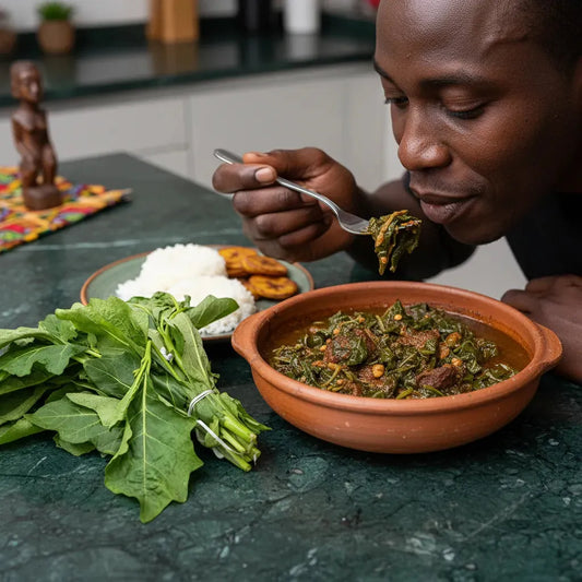 Homme dégustant un plat traditionnel préparé avec des feuilles d'aubergine africaines, accompagnées de riz et plantains frits.