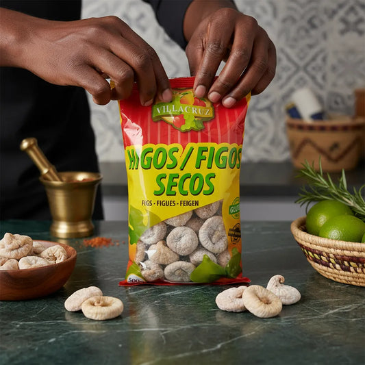Main ouvrant un sachet de figues sèches Calabacita VILLACRUZ sur plan de travail, produit d'épicerie sucrée riche en goût.