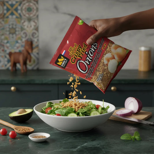 Main versant des oignons frits King's Harvest sur une salade verte, ajoutant une texture croustillante et savoureuse à vos plats.
