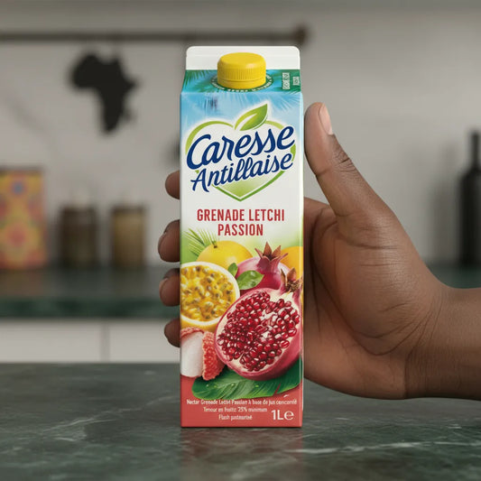 Main tenant une brique de nectar Grenade Letchi Passion Caresse Antillaise 1L, jus tropical aux saveurs intenses de fruits exotiques.