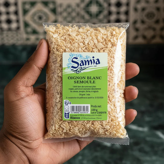 Main tenant un sachet de semoule d'oignon blanc SAMIA, épice pratique et savoureuse pour l'épicerie salée et la cuisine rapide.