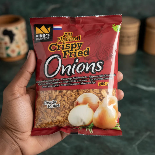 Sachet de 200g d'oignons frits King's Harvest tenu en main, produit prêt à l'emploi pour agrémenter vos plats avec croquant et goût.