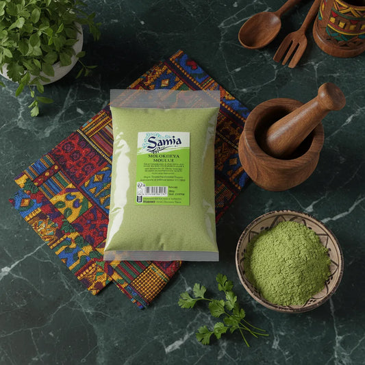 Molokheya moulu SAMIA présentée avec des ustensiles traditionnels et herbes fraîches, parfaite pour l'épicerie salée et les plats orientaux.