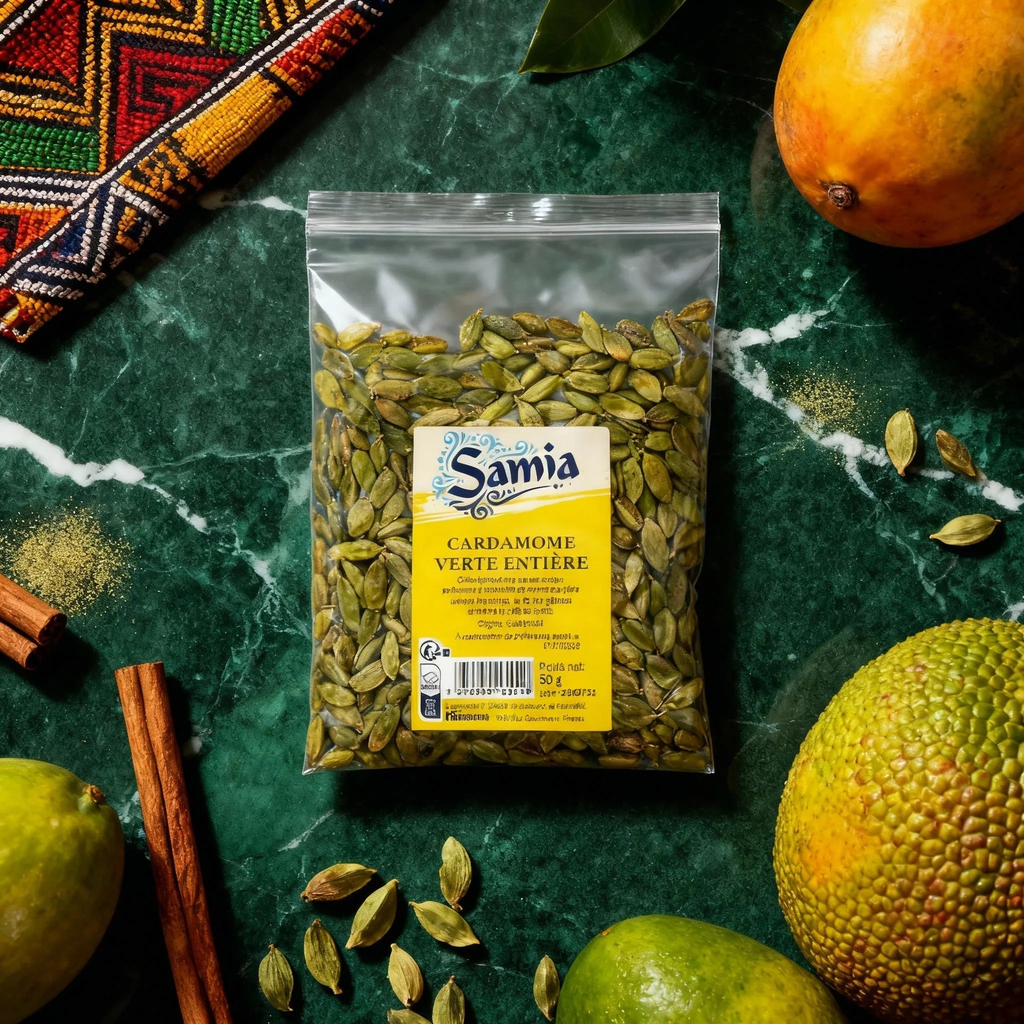 Sachet de cardamome verte entière SAMIA - Bio sur table avec fruits exotiques et cannelle. Épice aromatique pour cuisine du monde.