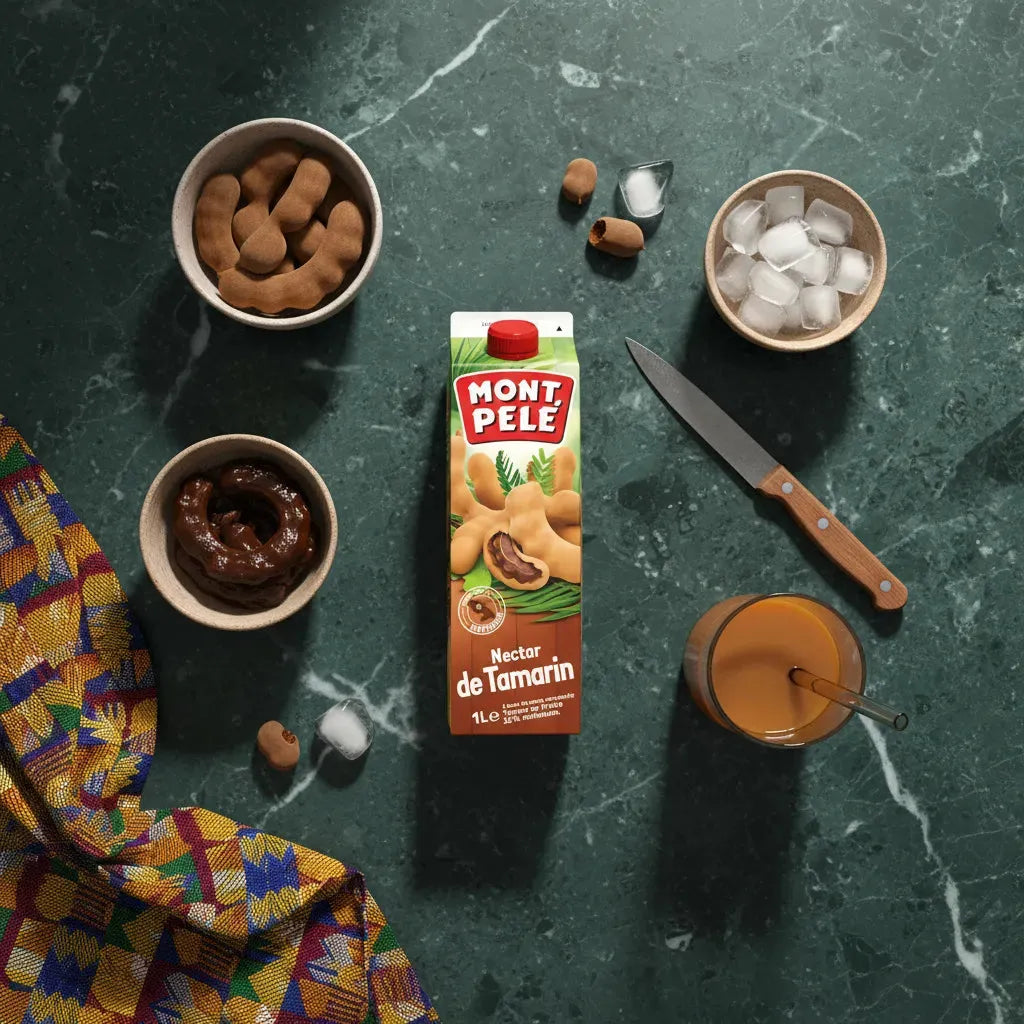 Brique de Nectar Tamarin MONTPELÉ entourée d’ingrédients naturels comme tamarins, glace et jus, sur fond de table en marbre vert.