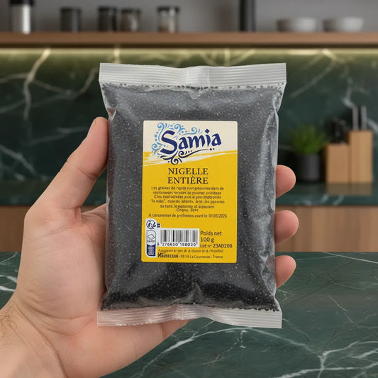Sachet de graines de nigelle SAMIA 100g tenu en main, parfait pour assaisonnement naturel et bienfaits santé en cuisine quotidienne.