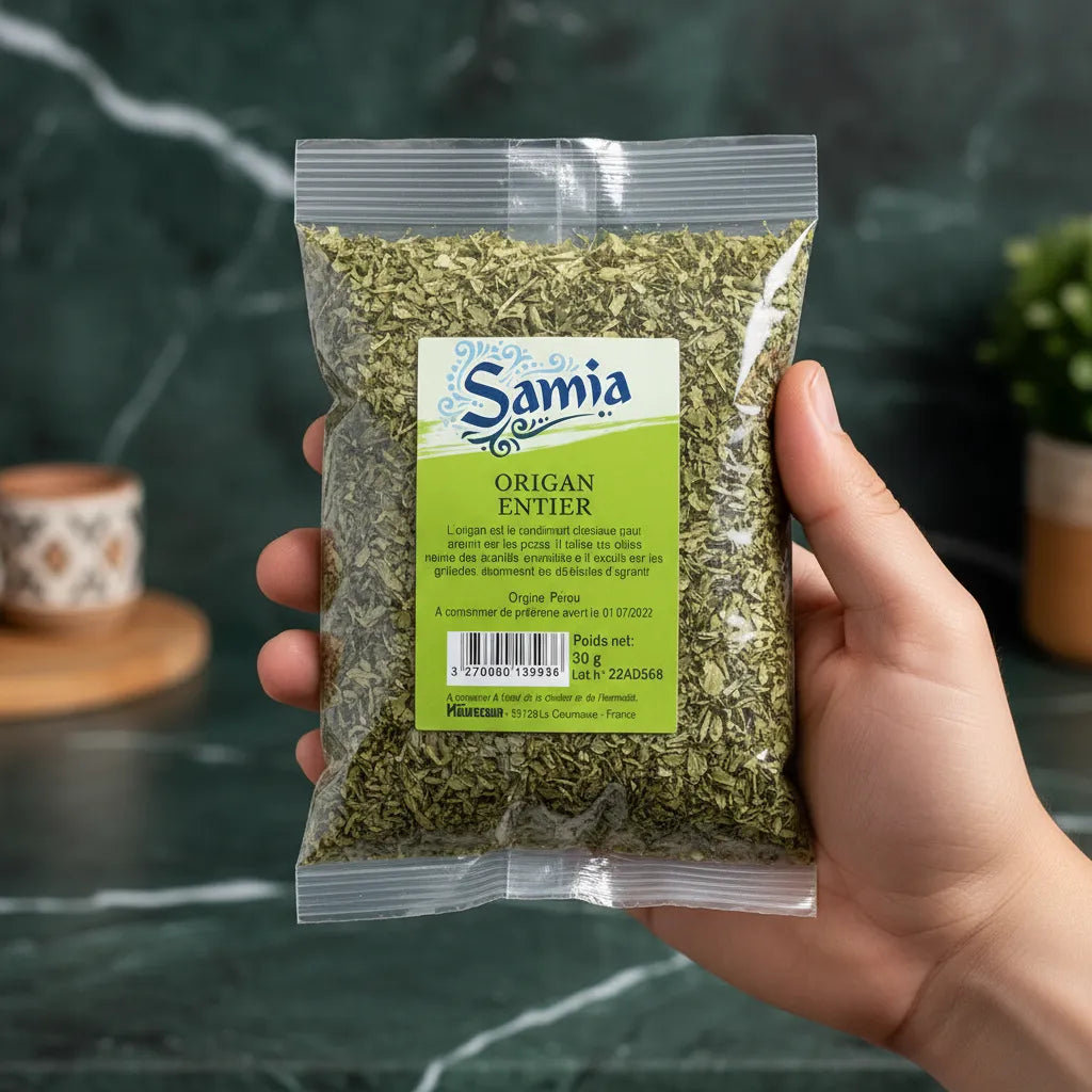 Sachet d’origan séché Samia tenu à la main, feuilles entières pour une saveur intense, produit d’épicerie salée de qualité.