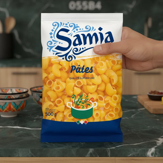 Main tenant un sachet de pâtes gomiti n°49 Samia, 500g, dans une cuisine moderne. Idéal pour plats gourmands d'épicerie salée.
