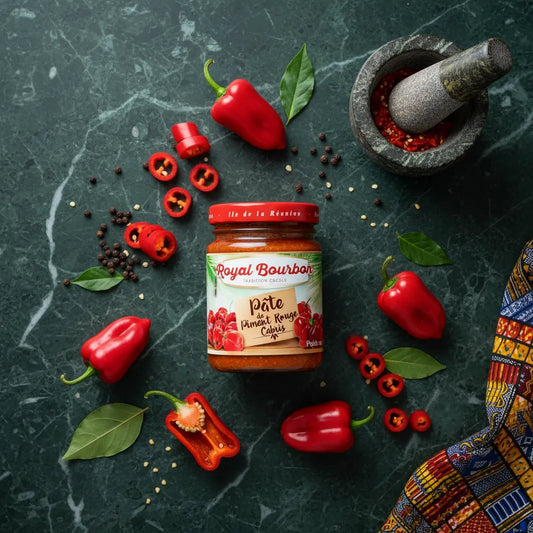 Pâte de piment rouge ROYAL BOURBON entourée de piments frais et épices, idéale pour la cuisine créole et les recettes relevées maison.