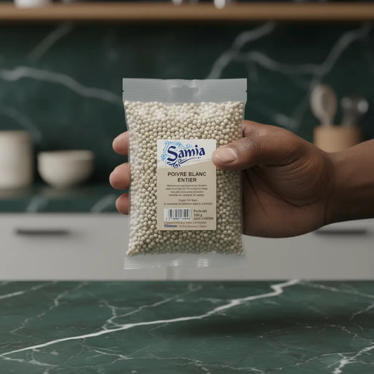 Main tenant un sachet de poivre blanc entier SAMIA - Épice aromatique de qualité pour cuisine du quotidien.