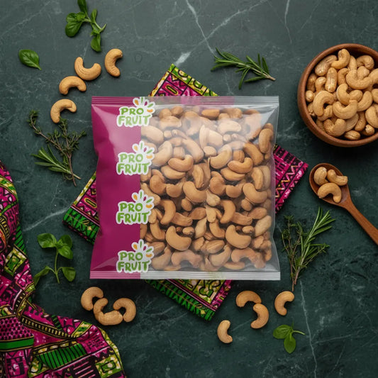 Sachet de noix de cajou grillées PROFRUIT posé sur une nappe colorée avec herbes fraîches, produit sec savoureux et croquant.