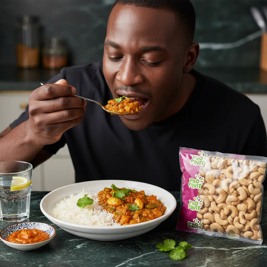 Homme dégustant un plat au curry accompagné de noix de cajou crues PROFRUIT, collation saine idéale pour enrichir les recettes maison.