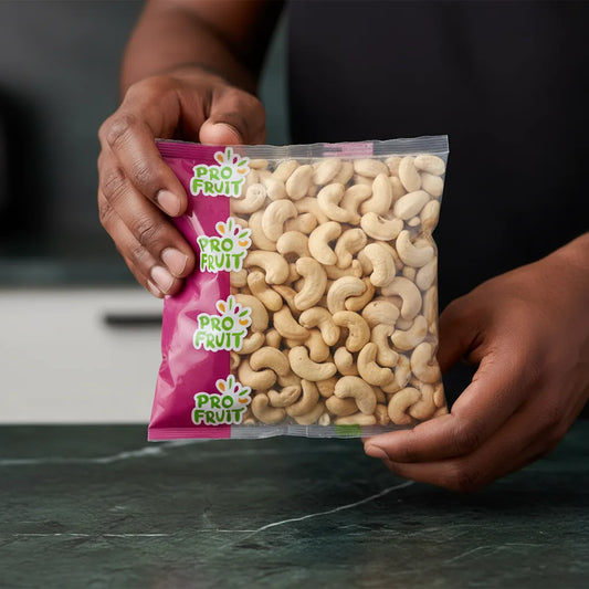 Main tenant un sachet de noix de cajou crues PROFRUIT, produit sain et croquant de la gamme fruits secs pour une alimentation équilibrée.