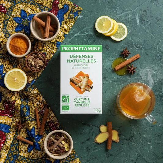 Infusion naturelle BIO PROPHYTAMINE posée sur une table avec ingrédients frais : curcuma, cannelle, citron et thé chaud pour l’immunité.