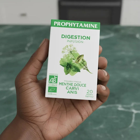 Main tenant une boîte d'Infusion Digestion BIO PROPHYTAMINE, infusion bio aux plantes comme menthe douce, carvi et anis pour faciliter la digestion.