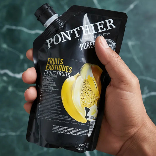 Main tenant le coulis de fruits exotiques PONTHIER, format pratique pour usage en cuisine. Mélange tropical pour épicerie sucrée.