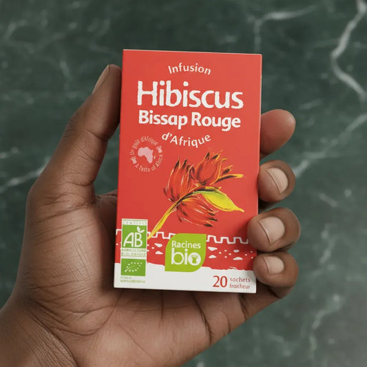 Boîte d'infusion Hibiscus Bissap Rouge BIO RACINES tenue en main, 20 sachets fraîcheur certifiés bio pour une infusion africaine.