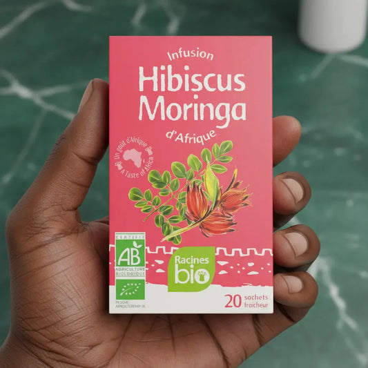 Infusion hibiscus moringa bio RACINES tenue en main, format compact de 20 sachets, idéale pour une dégustation saine et exotique.