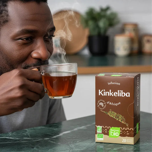 Homme dégustant une tasse d'infusion kinkeliba BIO Afrique Racines, boisson chaude aux vertus détoxifiantes et naturelles.