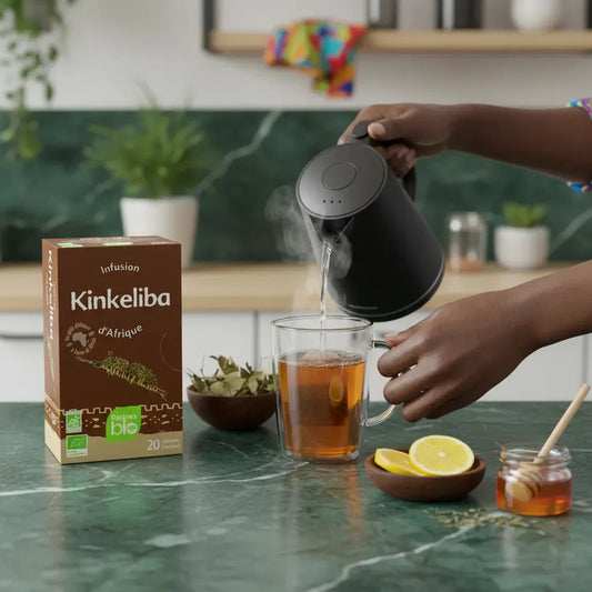 Préparation d'une tasse d'infusion kinkeliba BIO Afrique Racines avec eau chaude, citron et miel, boisson bien-être naturelle.