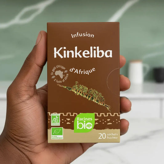 Boîte d'infusion kinkeliba BIO Afrique Racines tenue à la main, mettant en avant son label bio et ses bienfaits détoxifiants naturels.