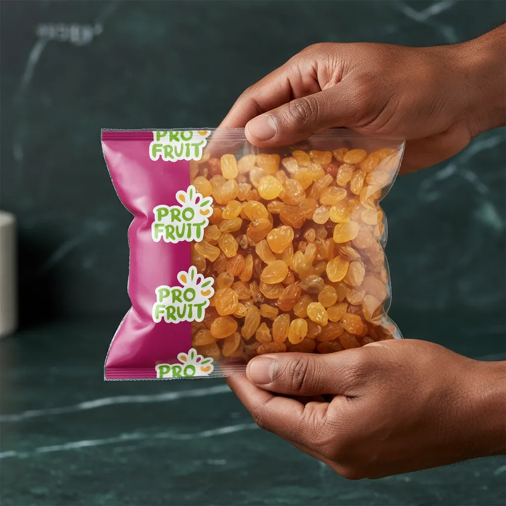 Main tenant un sachet de raisins Golden PROFRUIT, raisins secs moelleux et dorés, parfaits pour une alimentation naturelle et équilibrée.