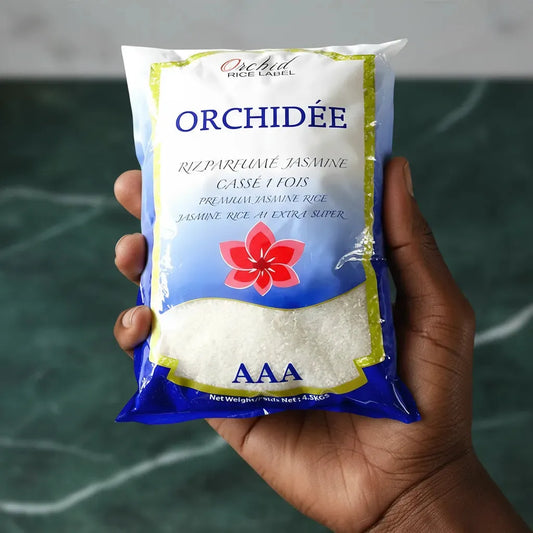 Main tenant un sachet de riz jasmin cassé 1 fois ORCHIDÉE AAA. Format pratique pour une utilisation quotidienne en épicerie salée.