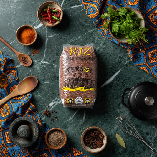 Riz rouge TERSOL au centre d'une table de cuisine décorée, entouré d'épices et ustensiles, pour sublimer vos plats naturellement.